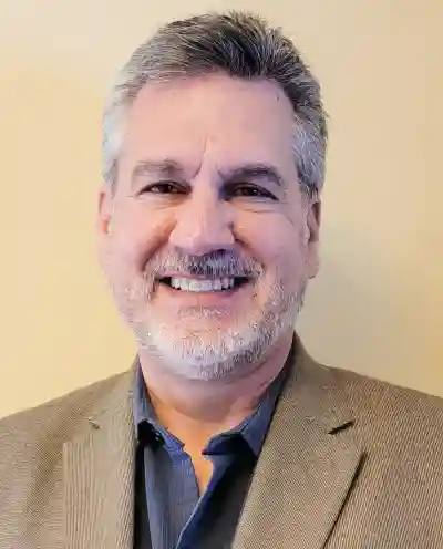 Photo of Randall Schrock smiling and wearing a suit