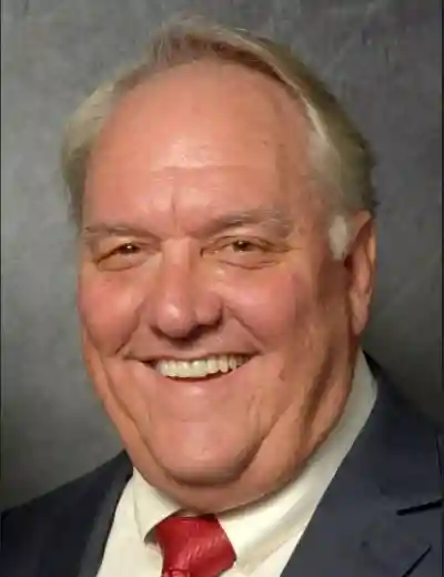 Doug Stewart smiling wearing a suit and tie